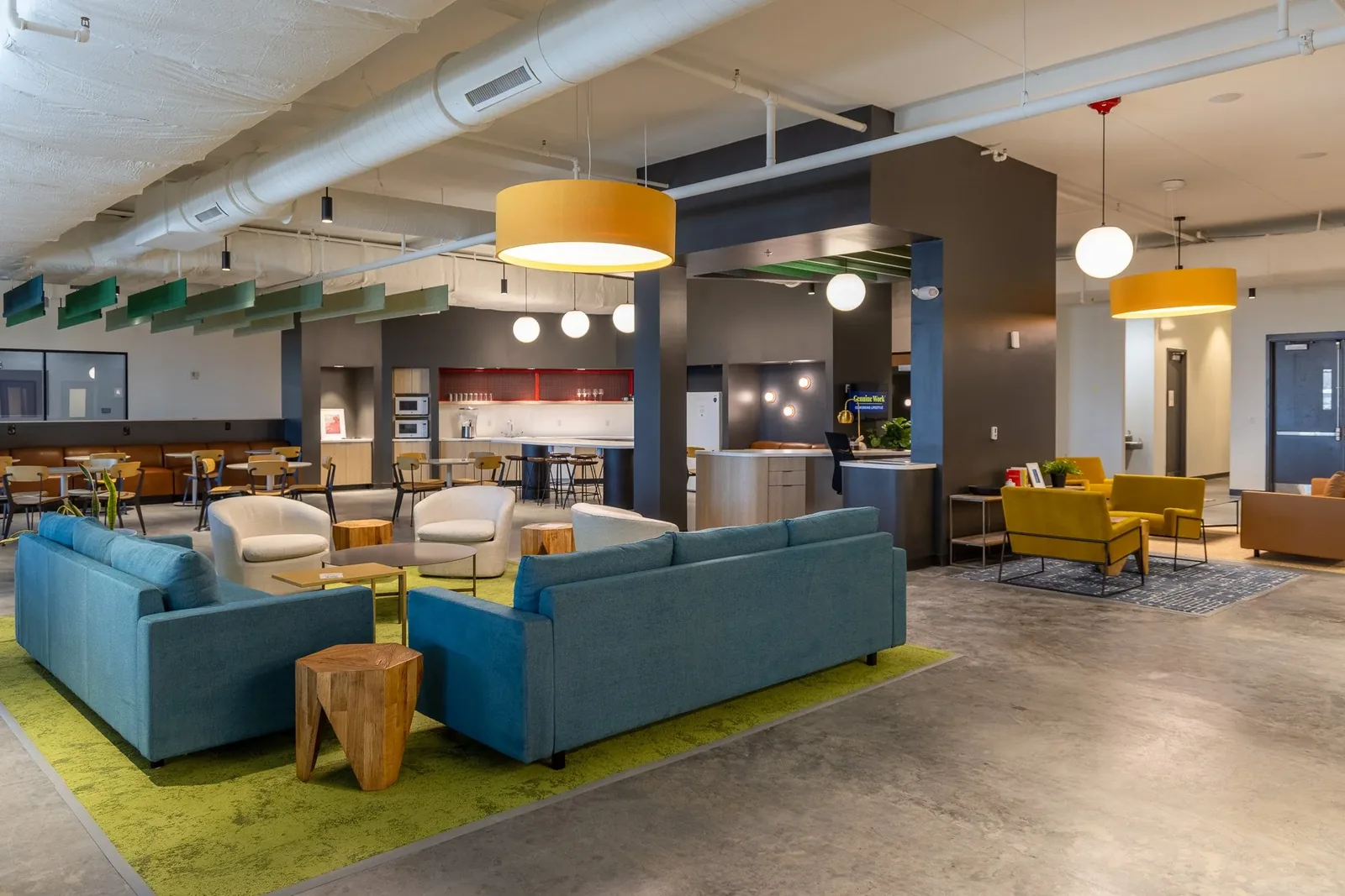 Genuine Works coworking lounge with teal couches and pendant lighting